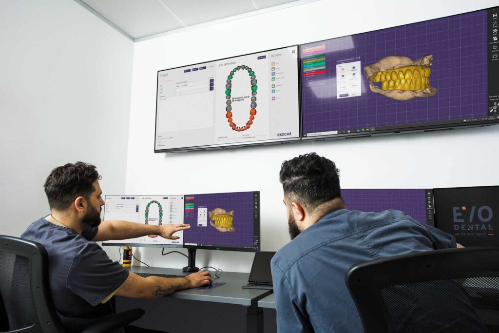 Two staff looking at a computer lab process